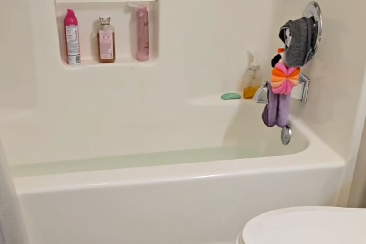 Slimy fingers reach out of the bathtub drain in squirm-inducing animal encounter