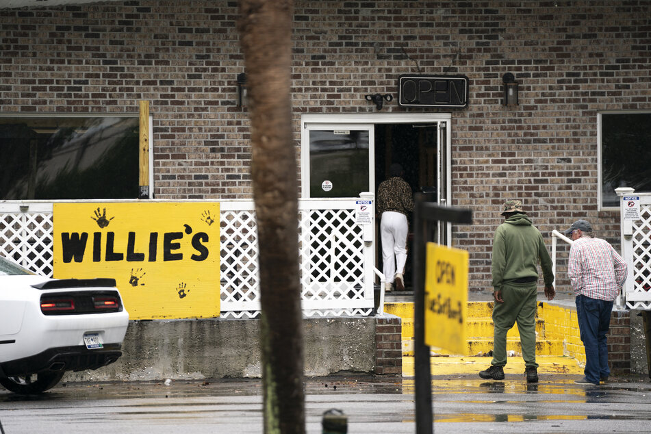 People walk into Willie's Bar & Grill after an early morning shooting on October 12, 2025, on St. Helena Island, South Carolina.
