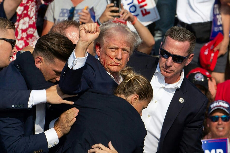 Donald Trump being carried away by Secret Service after several gunshots are fired during a rally in Butler, Pennsylvania on July 13, 2024.