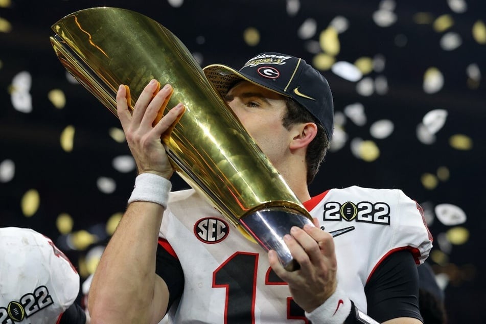 Quarterback Stetson Bennett of the Georgia Bulldogs kisses the National Championship trophy after the Georgia Bulldogs defeated the Alabama Crimson Tide.