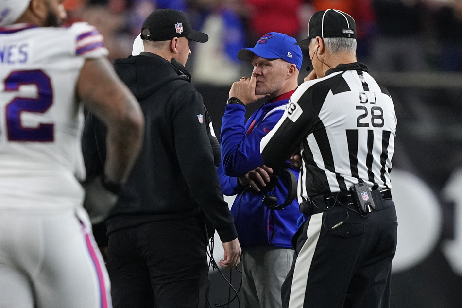 Bills coach Sean McDermott (center r) chats with Bengals head coach Zac Taylor (center l) after Damar Hamlin went into cardiac arrest mid-game.