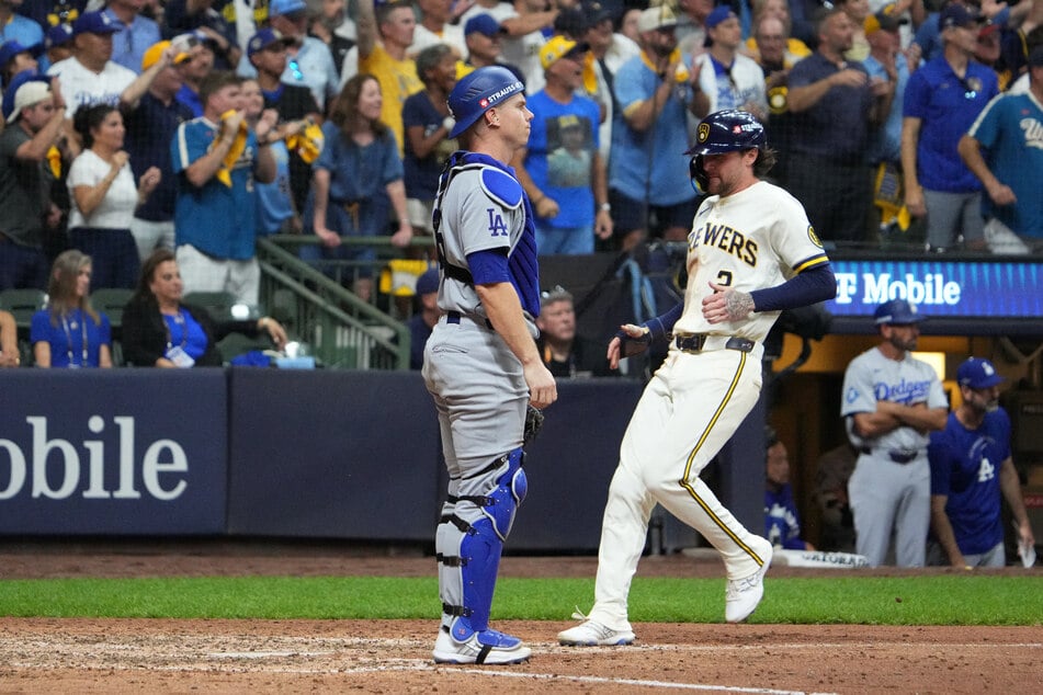 Milwaukee Brewers infielder Brice Turang scores a run on an RBI single hit by infielder Jake Bauers (not pictured) against Los Angeles Dodgers catcher Will Smith during the eighth inning in game two of the NLCS.
