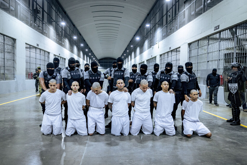 Salvadoran prison guards escort Venezuelans recently deported by the US government to be imprisoned in the maximum-security Terrorism Confinement Center.