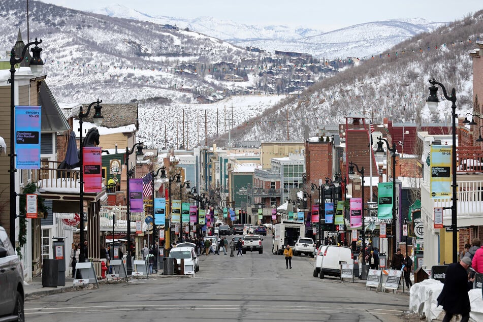 Signage hangs from lamp posts as people walk on Main Street during the 2024 Sundance Film Festival on January 23, 2024 in Park City, Utah.
