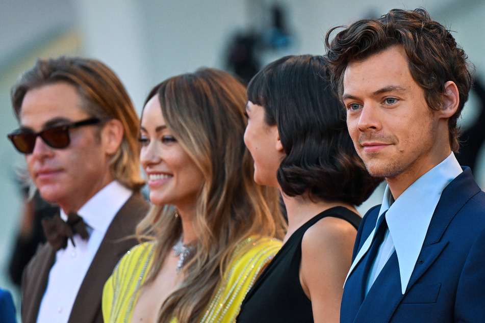 The Don't Worry Darling press tour was a popular topic of discussion on social media at the time, and Chris Pine (l.) has now cleared up the "spitting" debacle.