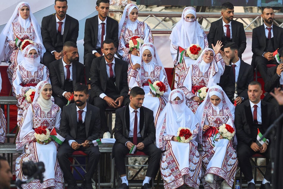 Palestinian couples are photographed during a mass wedding in Khan Younis on December 2, 2025.