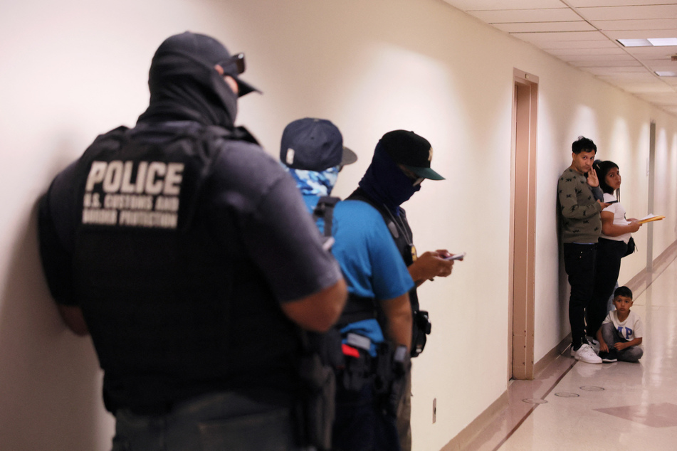 People wait to enter immigration court as federal agents patrol the halls at the Jacob K. Javitz Federal Building in New York City.