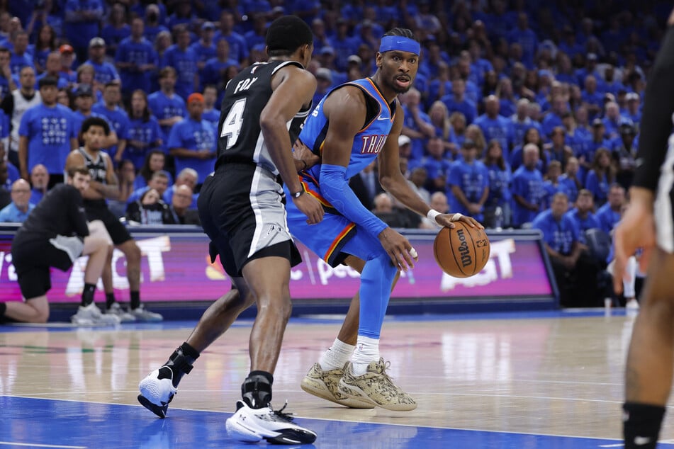 Oklahoma City Thunder guard Shai Gilgeous-Alexander controls the ball against San Antonio Spurs guard De'aaron Fox in the fourth quarter during game seven of the Western Conference Finals.