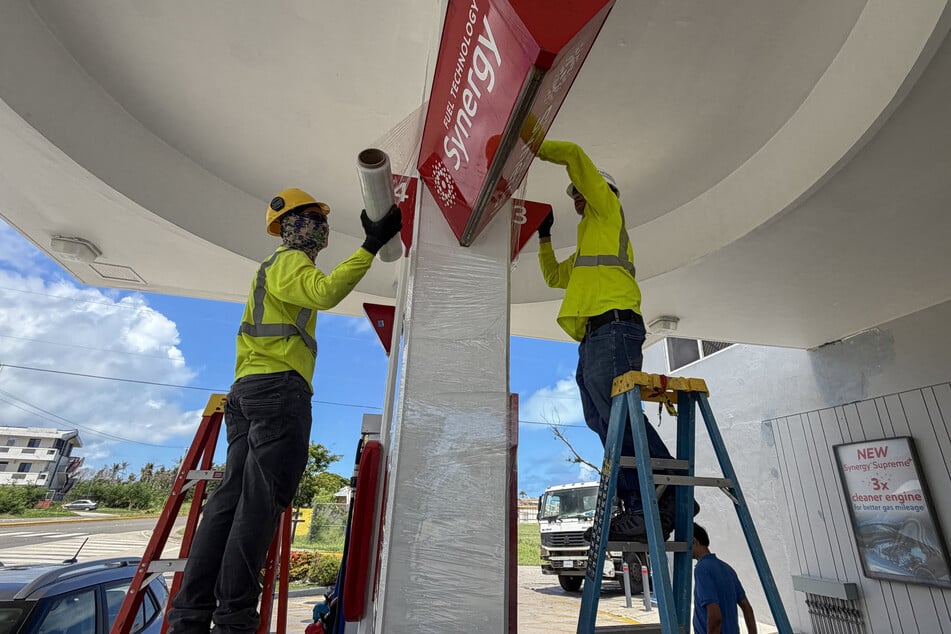 Workers secure a gas station ahead of the arrival of the forecasted Super Typhoon Bavi in Saipan, Northern Mariana Islands, on July 3, 2026.