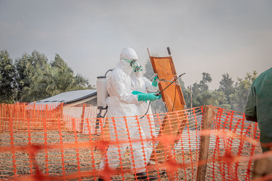 Healthcare workers disinfect a stretcher after transporting a patient suffering from the Ebola virus disease from an ambulance at the Ebola Treatment Center in Bunia, Ituri, in the east of the Democratic Republic of Congo, on June 23, 2026.