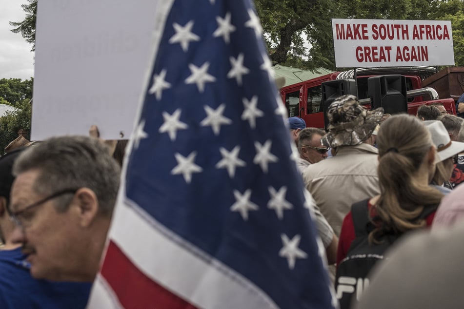 White South Africans supporting President Donald Trump and tech billionaire Elon Musk gather in front of the US Embassy in Pretoria on February 15, 2025.