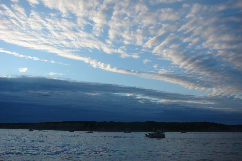 Fishing boats travel the Naknek River in Bristol Bay, Alaska, during the red salmon season.