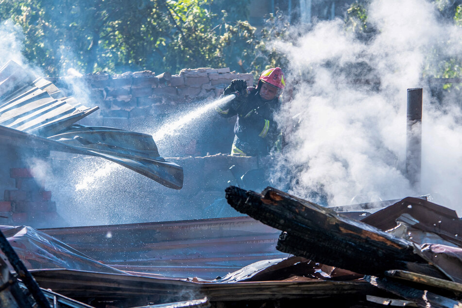 A Ukrainian rescuer works to extinguish a fire at the site of an air attack in Dnipro on June 2, 2026.