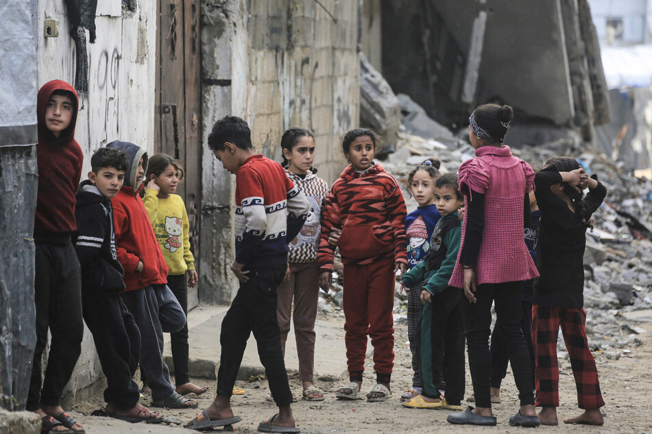 Palestinian children gather next to damaged buildings in Jabalia, in the northern Gaza Strip, on January 10, 2026.