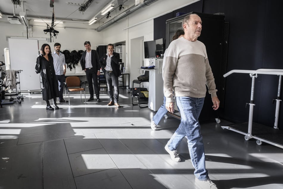A man with advanced Parkinson's disease named Marc (pictured, far right) is now able to walk almost "normally" again thanks to electrodes implanted in his spinal cord, researchers said on Monday.