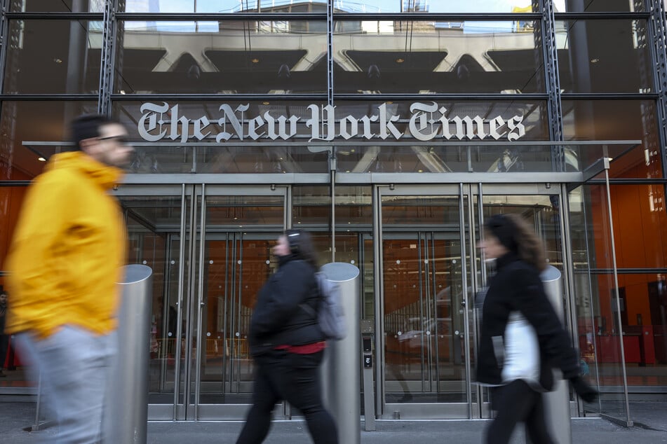 People pass in front of The New York Times building in New York City.