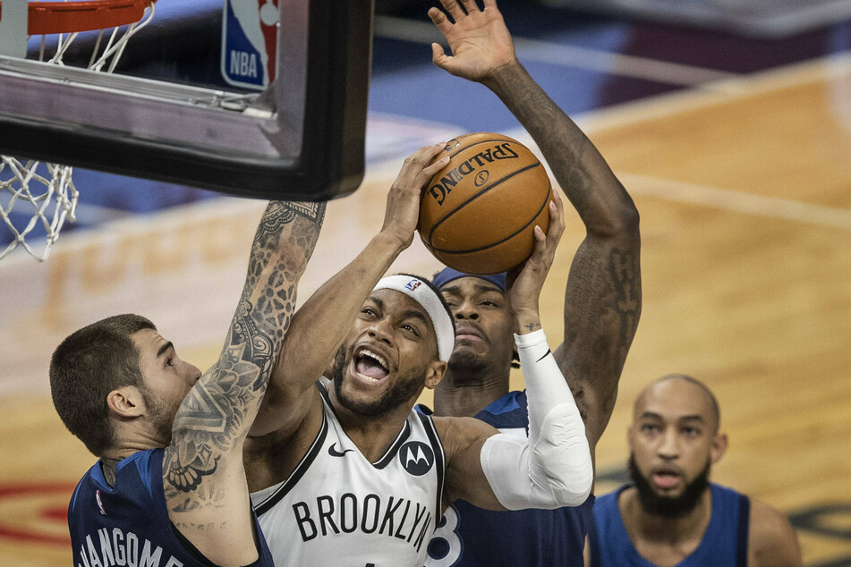 Nets forward Bruce Brown drives to the basket on Minnesota Timberwolves forwards Juancho Hernangomez and Jarred Vanderbilt.