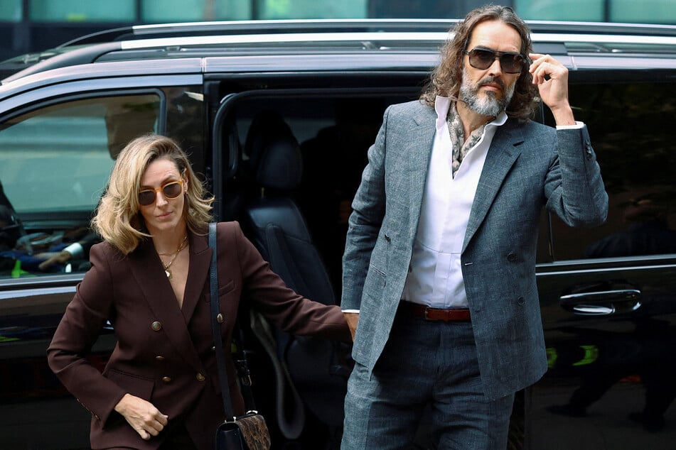Russell Brand (r.) and his wife Laura Brand (l.) arrive at Southwark Crown Court, where he is due to stand trial on charges of rape and sexual assault relating to six women, in London on October 12, 2026.