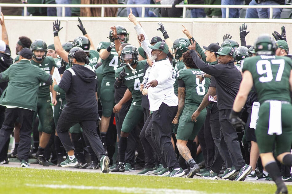 The Michigan State sideline celebrates a touchdown during Michigan State s 37-33 win over Michigan.