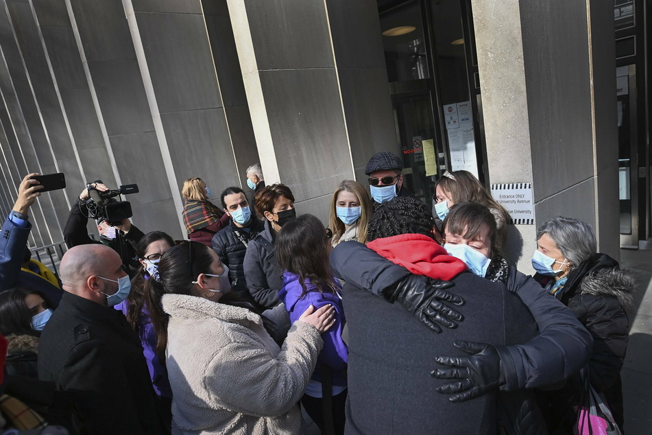 Survivors along with family and friends of survivors and victims share a moment outside the courthouse after the verdict.