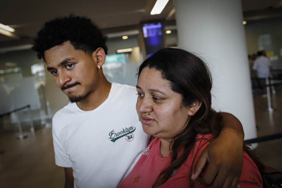 Emerson Colindres (l.) hugs his mother, Ada Bell Baquedano, upon her arrival at the Palmerola International Airport in Tegucigalpa, Honduras, on June 24, 2025.