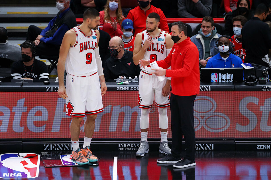 The Bull's Nikola Vucevic (l.) and Zach LaVine speaking to head coach Chris Fleming (r.).