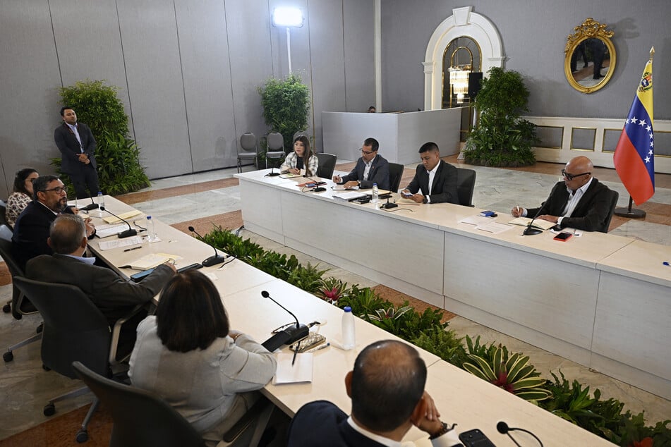 Venezuelan National Assembly President Jorge Rodriguez (r) attends a meeting with representatives of the government and opposition in Caracas on August 7.