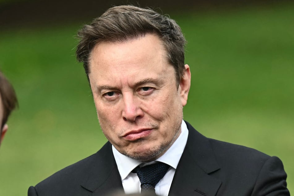 Elon Musk looks on as Speaker of the House Mike Johnson speaks to the press after a meeting with technology executives about AI at the White House on September 29. On Wednesday, Musk clapped back at Democrats seeking to investigate him for corruption.