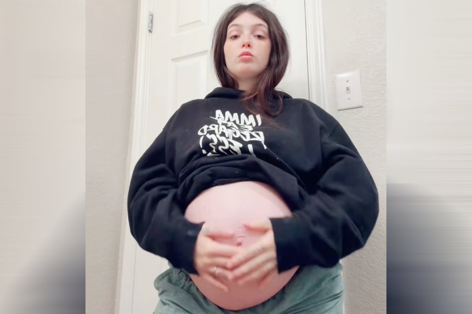 As the pregnant woman is expecting her third child in just a few weeks, her belly is quite large.