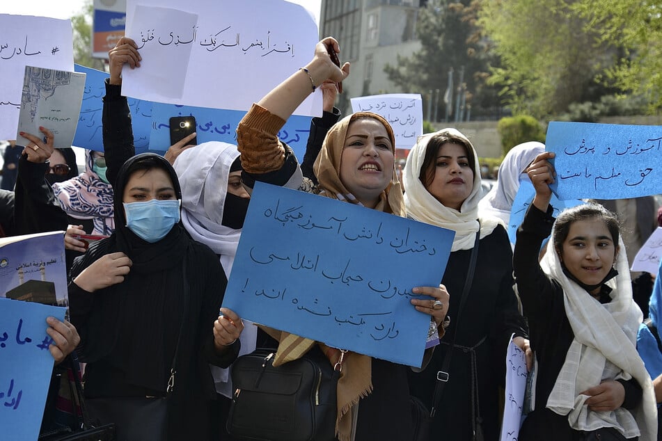Afghan women and girls take part in a protest in front of the Ministry of Education in Kabul on March 26, 2022, demanding that high schools be reopened for girls.
