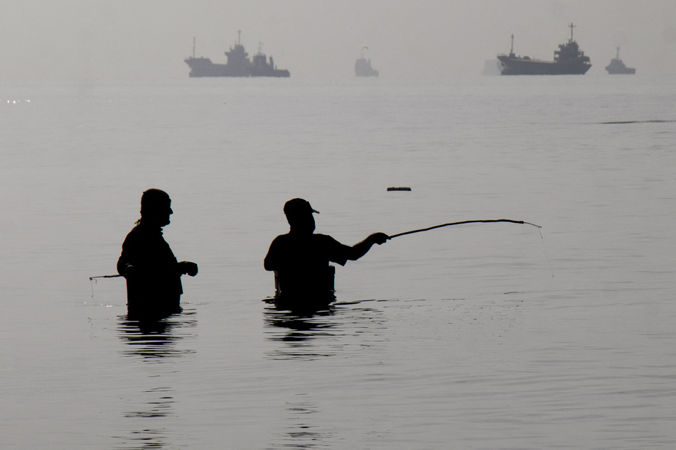 Iranian men fish at Suru Beach in Bandar Abbas along the Strait of Hormuz on April 24, 2026.