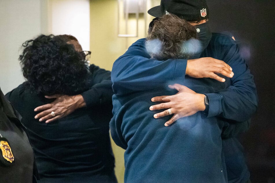 People hug after learning that their loved one is safe after a person shot and killed 8 people inside a FedEx building late Thursday night.