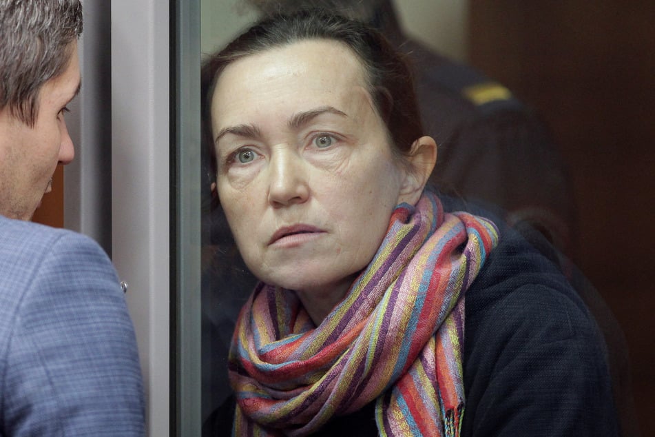 Alsu Kurmasheva listens to a lawyer while standing inside an enclosure for defendants as she attends a court hearing in Kazan, Russia, on December 1, 2023.