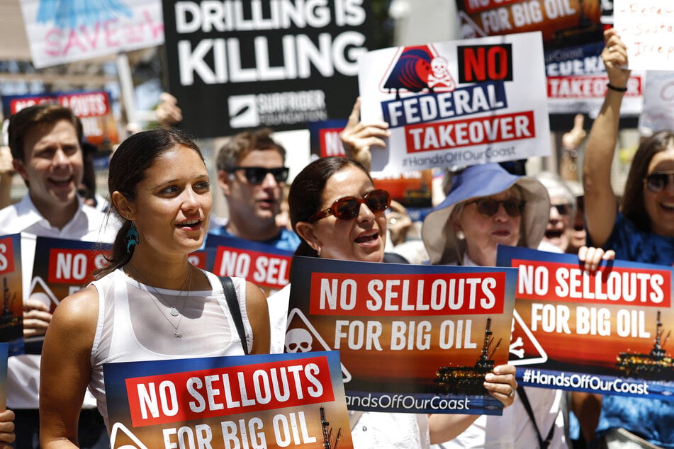Protesters hold signs at a press conference opposing a Trump administration NOAA review of California's coastline management authority on August 10, 2026.