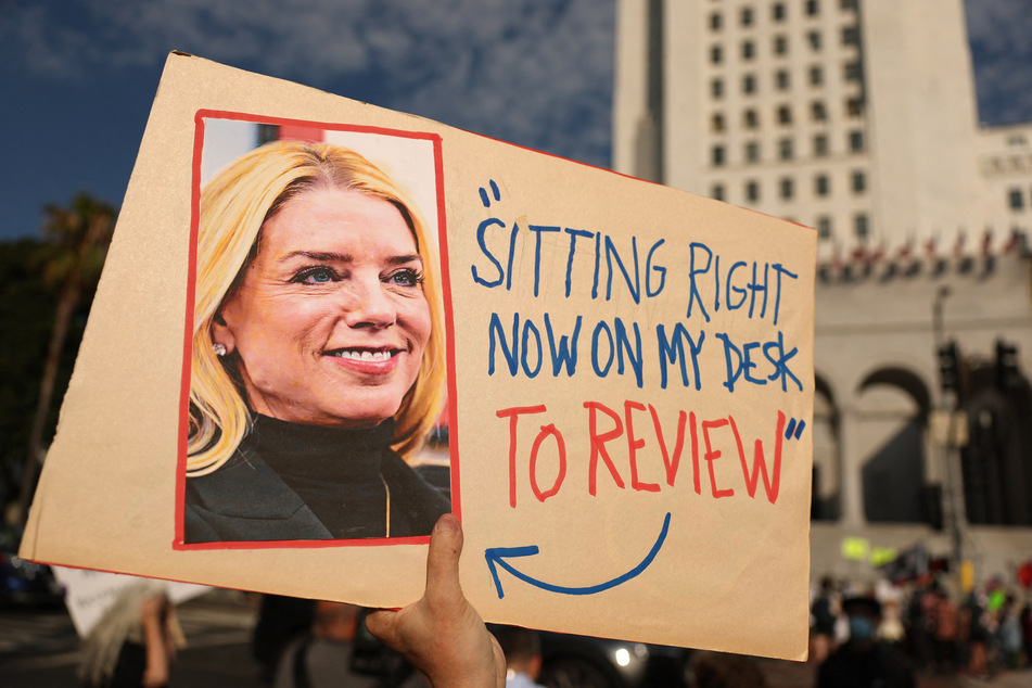 A person holds a sign with a photo of US Attorney General Pam Bondi and featuring a quote in reference to the Epstein files during a protest in Los Angeles, California, on July 17, 2025.