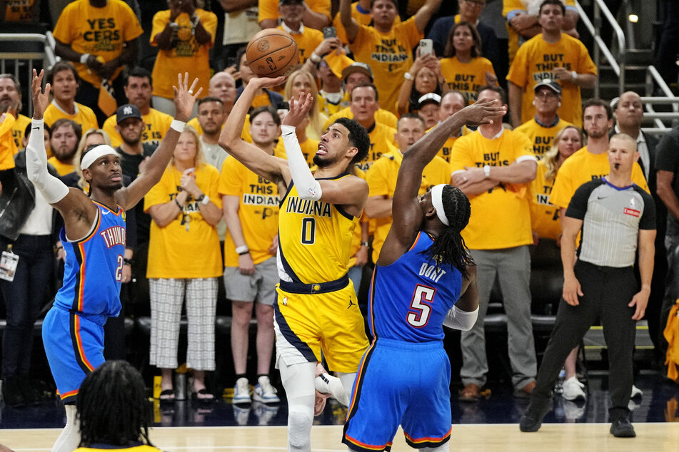 Indiana Pacers guard Tyrese Haliburton shoots the ball against Oklahoma City Thunder guard Shai Gilgeous-Alexander and guard Luguentz Dort in Game Three of the 2025 NBA Finals at Gainbridge Fieldhouse.