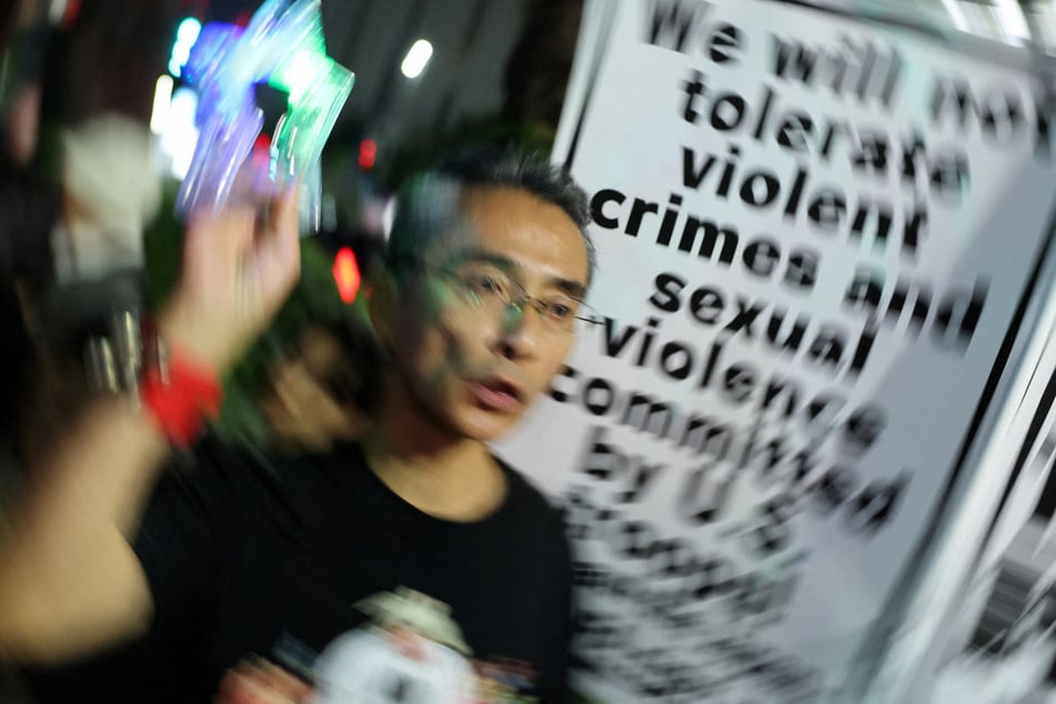 A demonstrator holds a sign during a protest outside the Foreign Ministry building in Tokyo, Japan, on October 8, 2026, following a US Marine's alleged killing of an Okinawa woman.
