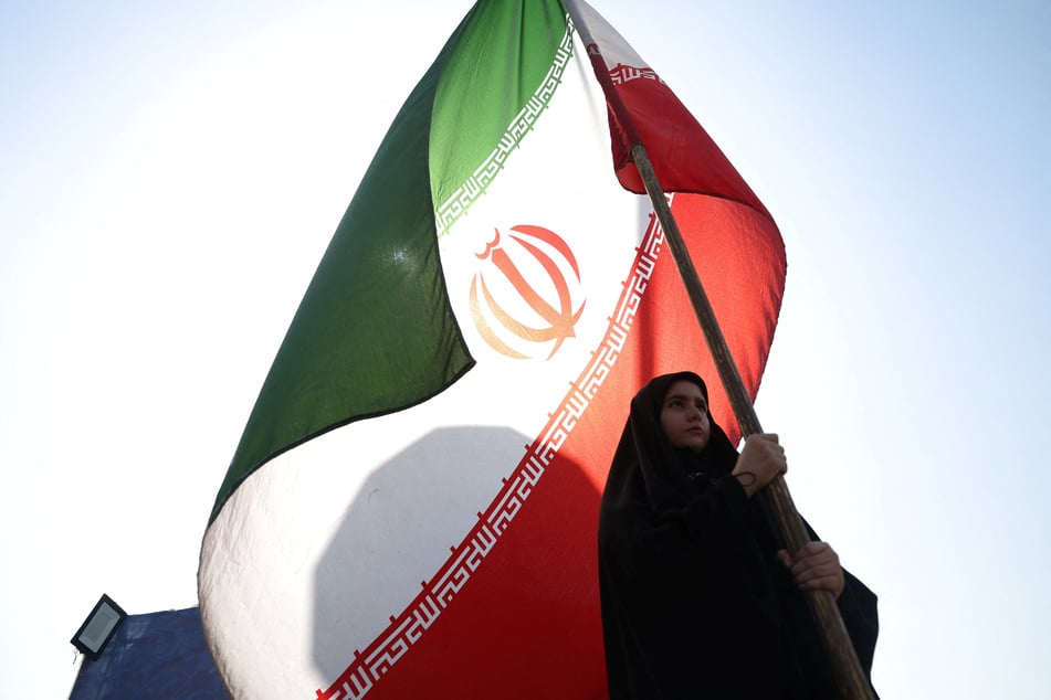 A woman holds an Iranian flag on a street in Tehran on June 10, 2026.