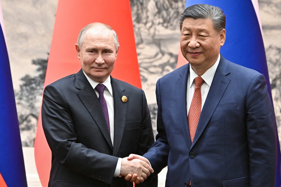 In this pool photograph distributed by the Russian state agency Sputnik, Russia's President Vladimir Putin (l.) and China's President Xi Jinping (r.) shake hands during their meeting in Beijing on May 16, 2024.
