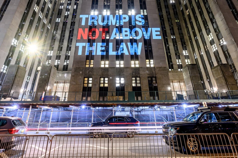 A projection that reads "Trump is Not Above the Law" is illuminated on the Manhattan Criminal Court on Sunday in New York City.