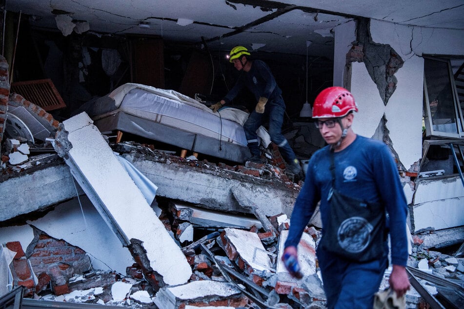 Emergency personnel move through the rubble of a damaged building after an earthquake, in Cali, Colombia, on August 10, 2026.