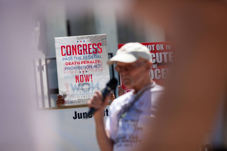 A sign calls for Congress to abolish the death penalty as Chuck Culhane, a former death row inmate, speaks in 2022.