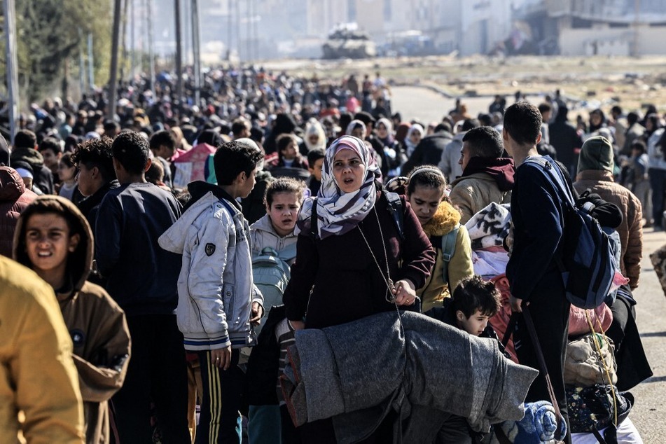 An Israeli tank takes position on the western outskirts of Khan Younis as scores of Palestinians flee the city's refugee camp.