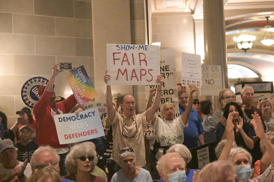 Protesters display signs in the rotunda of the Missouri State Capitol Building rejecting redistricting plans on September 10, 2025.