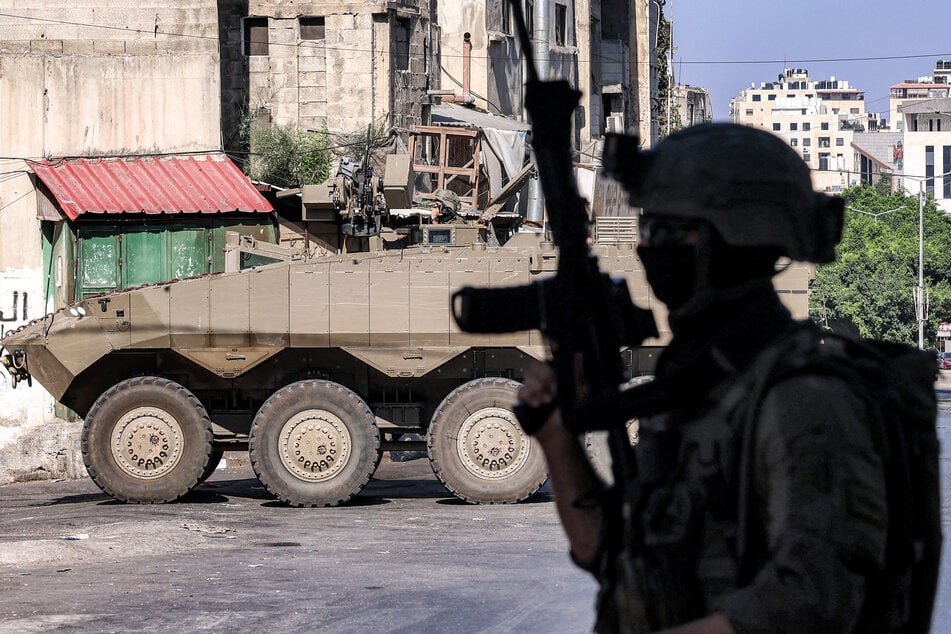 An Israeli soldier stands near an armored personnel carrier at the entrance of the Ain camp for Palestinian refugees, west of Nablus in the Israeli-occupied West Bank, on September 17, 2026.