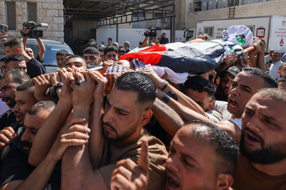 Mourners carry the body of 14-year-old Islam Ajouri at Rafidia Hospital in Nablus in the Israeli-occupied West Bank on August 23, 2026.