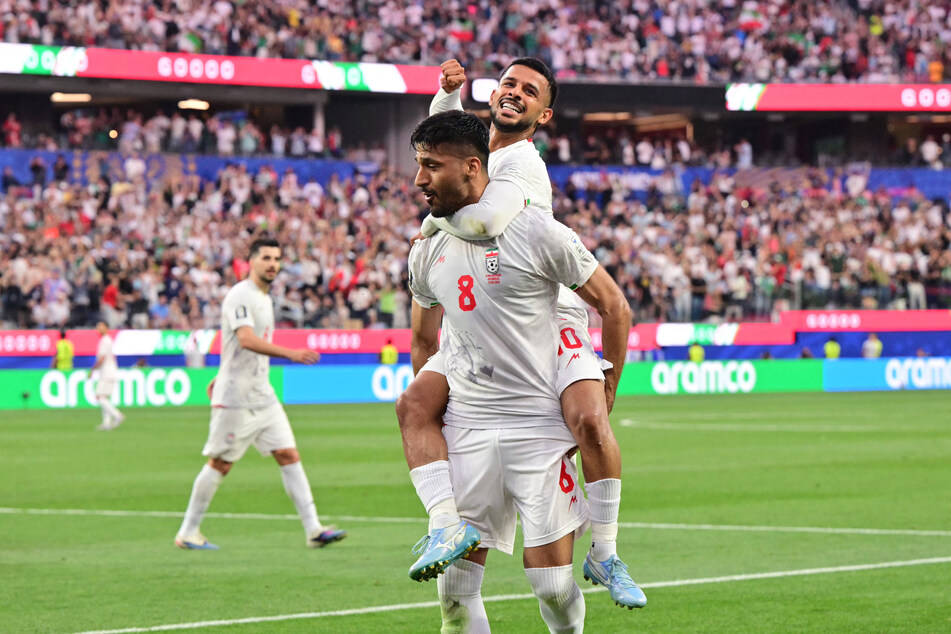 Iran's midfielder Mohammad Mohebbi celebrates scoring his team's second goal with teammate Mehdi Ghayedi during the World Cup Group G match against New Zealand on June 15, 2026.