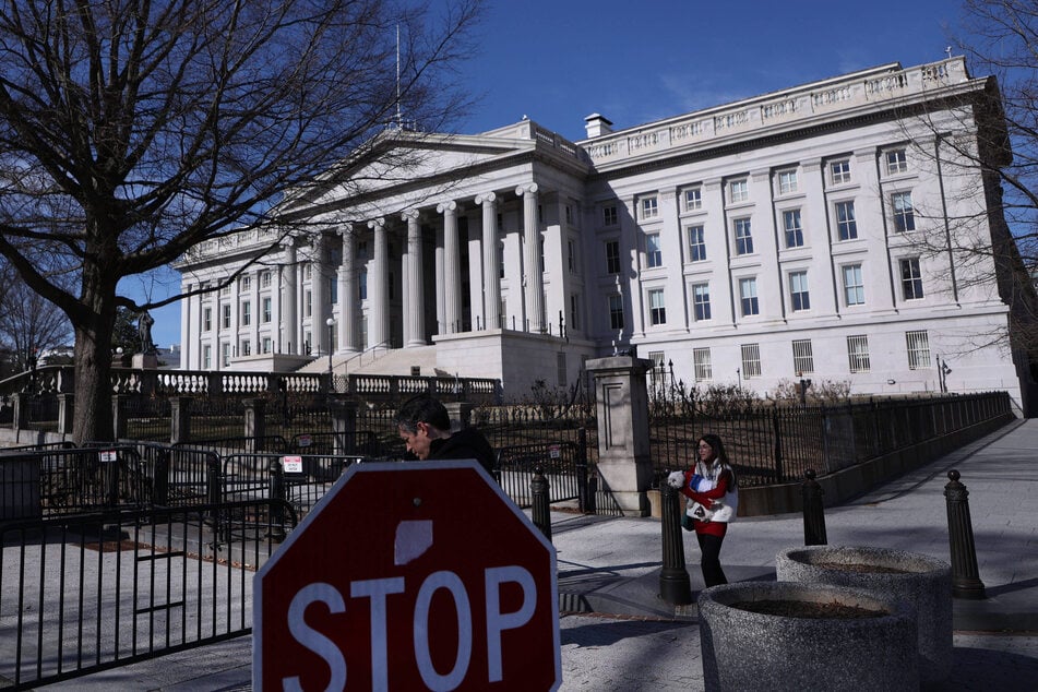 People walk past the US Treasury Building in Washington DC.