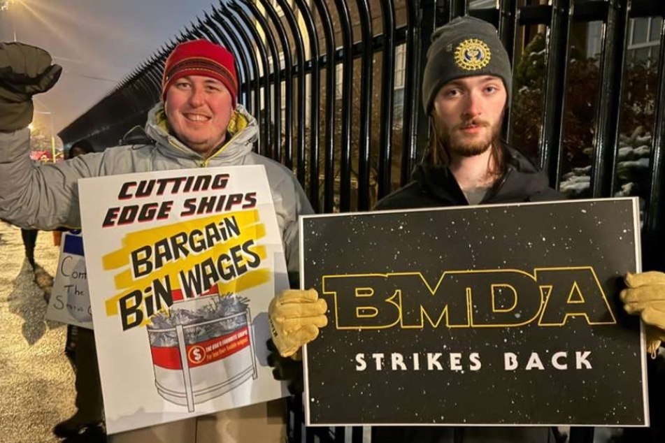 Bath Marine Draftsmen's Association members hold signs during a strike at General Dynamics Bath Iron Works in Maine on March 23, 2026.