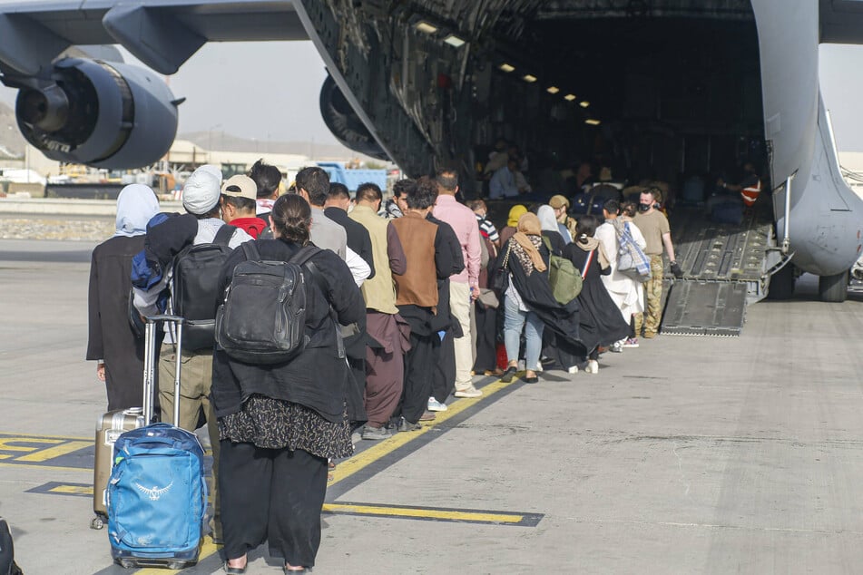Evacuees board a plane departing from Kabul Airport in Afghanistan.